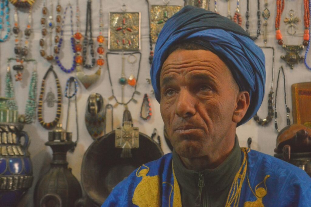 Moroccan Artisan with handmade products in the background